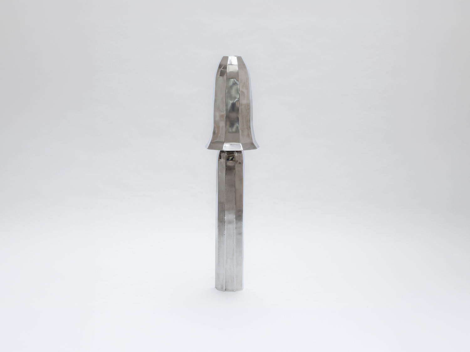 Faceted polished stainless-steel form, a flared bell-like top above a slender column, floating on a pale grey ground — Studio Kuhlmann Foxglove