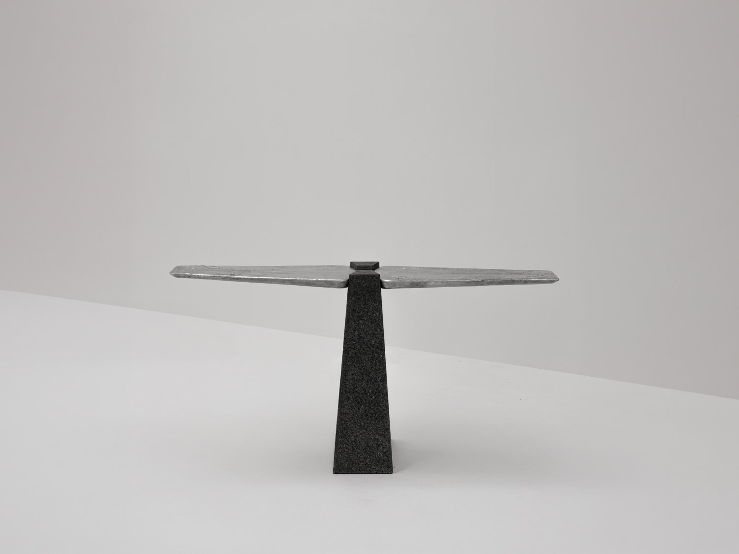 Console table with a cast-aluminium winged top balanced on a tapering pyramidal charcoal volcanic stone pedestal — EWE Studio EXHUMA Console